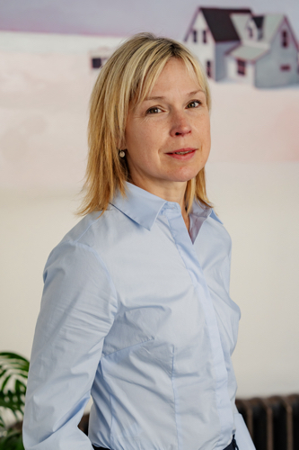 A portrait of Bethany Macdonald wearing a blue tailored shirt